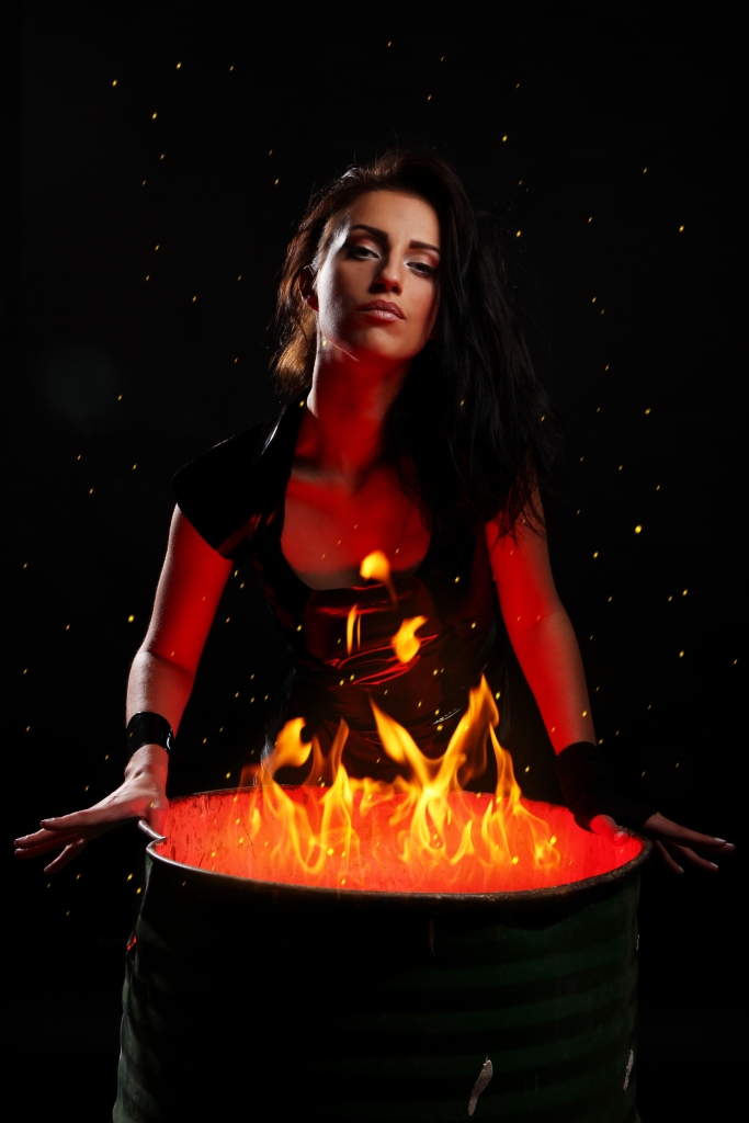 Mujer sexy junto a un barril lleno de fuego
